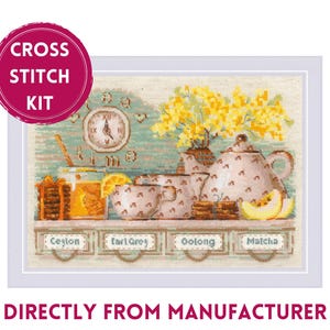 May include: Cross stitch kit featuring a tea-themed design. The image shows a teapot, cups, and a clock, with labels for Ceylon, Earl Grey, Oolong, and Matcha. The background is a light teal color.