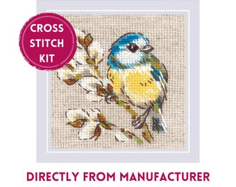 May include: Cross stitch kit featuring a blue and yellow bird perched on a branch with white blossoms. The kit includes all the materials needed to complete the project.  "Cross Stitch Kit" is written in red on a white circle.