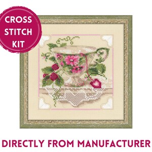 May include: Cross stitch kit featuring a vintage teacup with pink flowers and a heart on a lace doily. The teacup is surrounded by green leaves and pink berries.
