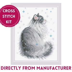 May include: Cross stitch kit featuring a gray and white cat sitting with a blue background and white snowflakes. The kit includes all the materials needed to complete the project.  "Cross Stitch Kit" is written in a red circle at the top left of the image.