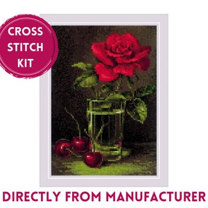 May include: Cross stitch kit featuring a red rose in a glass vase with three red cherries on a green surface. The kit includes all the materials needed to complete the project.