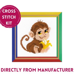 May include: Cross stitch kit featuring a cartoon monkey holding a banana. The kit is in a colorful frame with a red, yellow, blue, and green border. The text "CROSS STITCH KIT" is in a red circle.
