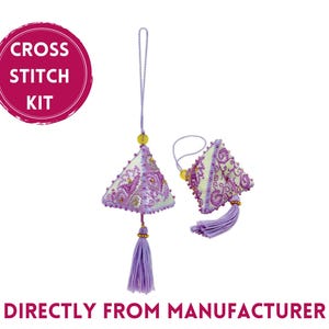May include: Cross stitch kit with two purple and white triangle ornaments with tassels. The ornaments are decorated with floral embroidery. The kit includes all the materials needed to create the ornaments.