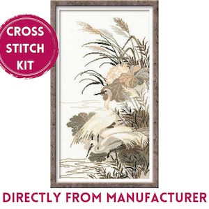 May include: Cross stitch kit featuring a framed, detailed embroidery of two white herons in a serene wetland scene. The artwork includes beige, brown, and green foliage, with the text "CROSS STITCH KIT" and "DIRECTLY FROM MANUFACTURER".