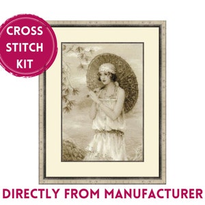 May include: Cross stitch kit featuring a woman in a white dress holding a parasol, standing in front of a beach scene. The image is in sepia tones.