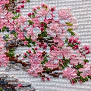 The RIOLIS cross stitch kit Flowering Bonsai features a delicate bonsai design using 17 colors of wool/acrylic threads. The kit includes a needle, Zweigart 14ct white AIDA fabric, and a color chart. The finished size is 30x24 cm (11¾in x 9½in).