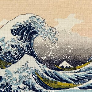 The RIOLIS cross stitch kit The Great Wave off Kanagawa after K. Hokusai Artwork features a detailed design using 17 colors of Anchor stranded cotton threads. The kit includes a needle, Zweigart 14ct white AIDA fabric, and a color chart.