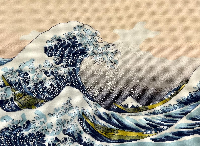 The RIOLIS cross stitch kit The Great Wave off Kanagawa after K. Hokusai Artwork features a detailed design using 17 colors of Anchor stranded cotton threads. The kit includes a needle, Zweigart 14ct white AIDA fabric, and a color chart.