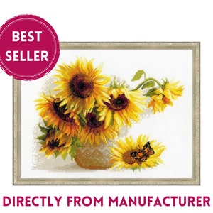 May include: Cross-stitch artwork of sunflowers in a vase, with a butterfly on one flower. The artwork is framed and features the text "BEST SELLER" and "DIRECTLY FROM MANUFACTURER". The sunflowers are yellow and brown.