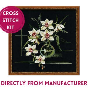 May include: A cross stitch kit featuring a square framed embroidery of white orchids with dark red centers in a clear glass vase against a black background. The image includes the text CROSS STITCH KIT and DIRECTLY FROM MANUFACTURER.