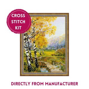 May include: Cross stitch kit featuring a scenic landscape with a wooden bridge over a stream, surrounded by birch trees with yellow leaves. The background features a forest with hills in the distance.