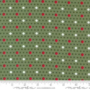 May include: Green fabric with a repeating pattern of white and red dots and small stars. The fabric is measured with a ruler in inches.