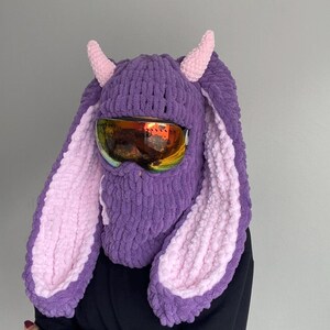 Puede incluir: Sombrero de conejo de punto morado y rosa con gafas de esqu&iacute;. El sombrero tiene orejas largas y ca&iacute;das y una m&aacute;scara facial.