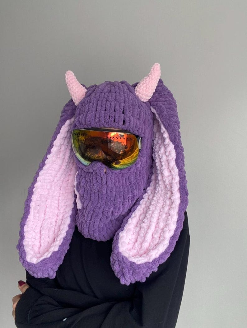 Puede incluir: Sombrero de conejo de punto morado y rosa con gafas de esqu&iacute;. El sombrero tiene orejas largas y ca&iacute;das y una m&aacute;scara facial.