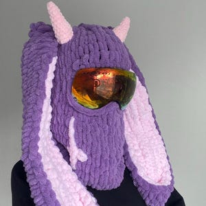 Puede incluir: Sombrero de conejo de punto morado y rosa con orejas largas y una m&aacute;scara de esqu&iacute;.