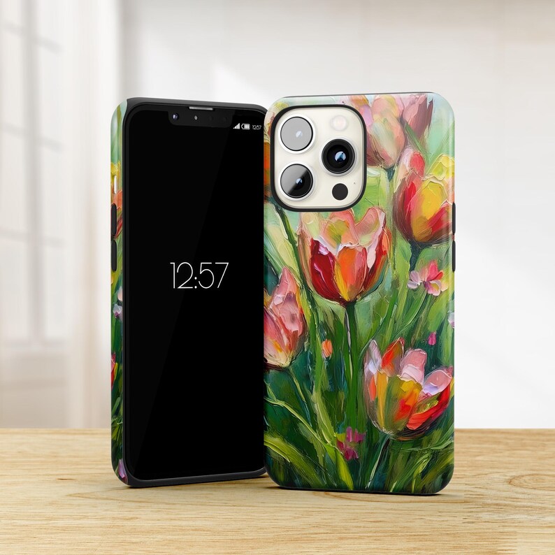 May include: A phone case with a colorful painting of tulips on a green background. The case has a black border and a cutout for the camera lens.