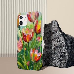 May include: A phone case with a colorful painting of tulips in shades of red, pink, and yellow. The flowers are painted in a realistic style with visible brushstrokes. The background is a green and white abstract design.
