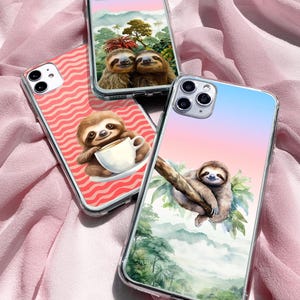 May include: Three clear phone cases with different sloth designs. The first case has a pink and blue gradient background with a sloth hanging from a branch. The second case has a red and white striped background with a sloth holding a cup of coffee. The third case has a pink and blue gradient background with two sloths cuddling.