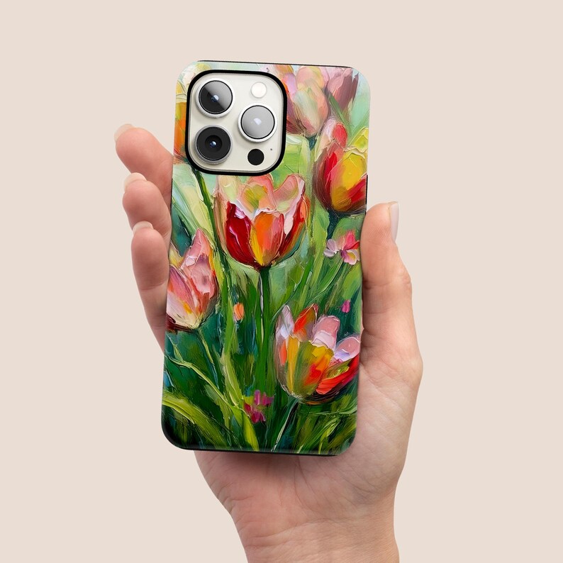 May include: A phone case with a colorful painting of tulips on a green background. The case has a camera cutout and a white border.