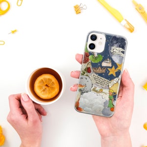 Puede incluir: Funda de tel&eacute;fono transparente con un dise&ntilde;o inspirado en "El Principito". La funda presenta ilustraciones de un zorro, estrellas, una corona y texto. En el fondo se sostiene una taza de t&eacute; con una rodaja de lim&oacute;n.