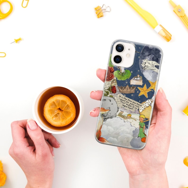 Puede incluir: Funda de tel&eacute;fono transparente con un dise&ntilde;o inspirado en "El Principito". La funda presenta ilustraciones de un zorro, estrellas, una corona y texto. En el fondo se sostiene una taza de t&eacute; con una rodaja de lim&oacute;n.