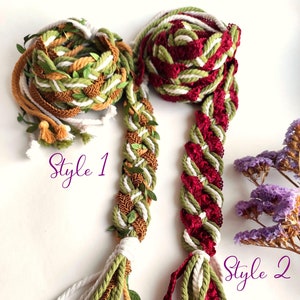 May include: Two styles of braided rope trim with tassels. Style 1 is a white, green, and gold rope with green leaves. Style 2 is a white, green, and burgundy rope.
