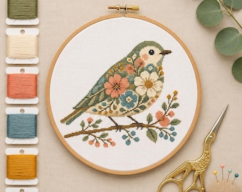 May include: A cross-stitch project in a round wooden hoop featuring a bird with floral patterns in pink, white, and blue on its body, perched on a branch. Beside it are six bobbins of embroidery floss in various colors, gold stork scissors, and a pin cushion.