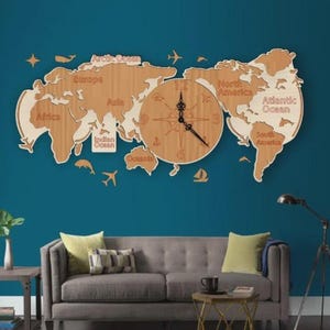 May include: A wooden world map wall clock with a natural wood finish. The clock features a compass design in the center and is surrounded by continents and oceans. Decorative elements include airplanes, dolphins, and a sailboat.