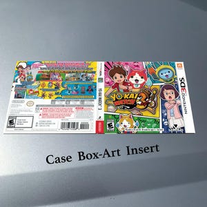 Può includere: Inserto per custodia di gioco Yo-Kai Watch 3 per Nintendo 3DS. La copertina presenta un'illustrazione colorata con personaggi e il titolo del gioco. La copertina posteriore presenta dettagli e schermate del gioco. Il testo "Case Box-Art Insert" è in basso.