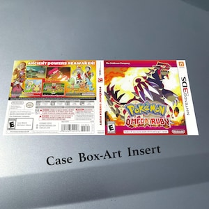 May include: A Nintendo 3DS game case insert for Pokémon Omega Ruby. The cover features a red and white dragon-like creature with the game title. The back shows characters and scenes from the game, with the text "ANCIENT POWERS REAWAKEN!"