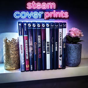 Puede incluir: Una fila de once cajas de videojuegos con la marca Steam, incluyendo títulos como Resident Evil, Red Dead Redemption 2 y Alan Wake 2. Sobre las cajas, un letrero de neón muestra el texto steam cover prints en luz azul y rosa.