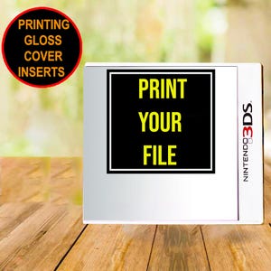 May include: A white Nintendo 3DS game case with a black square insert featuring the yellow text PRINT YOUR FILE. A circular red-bordered badge in the upper left corner contains the black text PRINTING GLOSS COVER INSERTS in yellow font.
