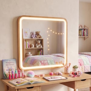 Può includere: Una scrivania da toeletta rettangolare in legno chiaro con un cassetto integrato etichettato 'Mila's Vanity'. Sopra la scrivania si trova uno specchio da parete quadrato con angoli arrotondati, cornice luminosa a LED e orologio digitale.