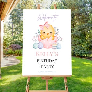 Puede incluir: Un letrero blanco sobre un caballete con el texto "Welcome to Keily's Birthday Party" y una ilustración en acuarela de un pollito saliendo de un huevo. El pollito tiene un lazo rosa y está rodeado de huevos de Pascua.