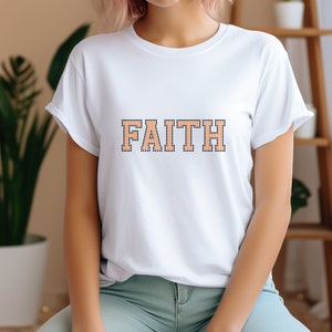 May include: White t-shirt with the word "FAITH" printed in orange and black outlined letters.
