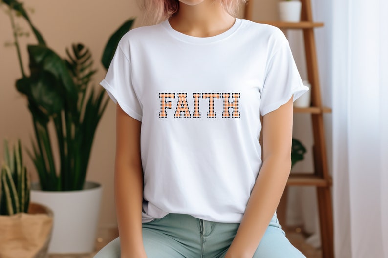 May include: White t-shirt with the word "FAITH" printed in orange and black outlined letters.