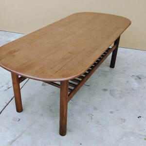 mid century modern coffee table crafted from solid walnut wood with  slatted lower shelf for
