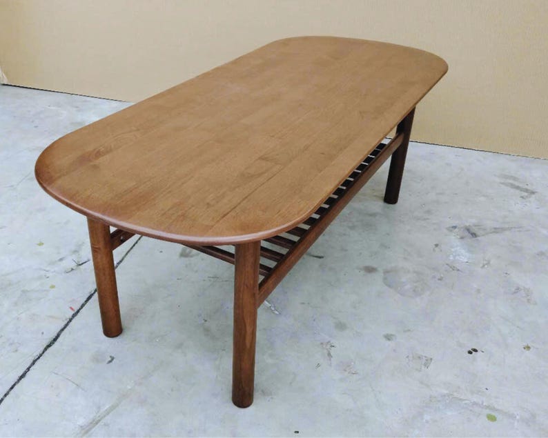 mid century modern coffee table crafted from solid walnut wood with  slatted lower shelf for