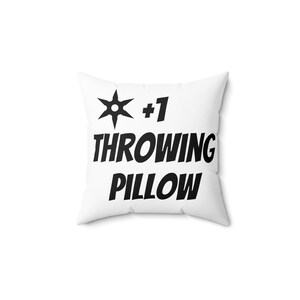 May include: White pillow with black text that reads "#1 Throwing Pillow" and a black star shape.