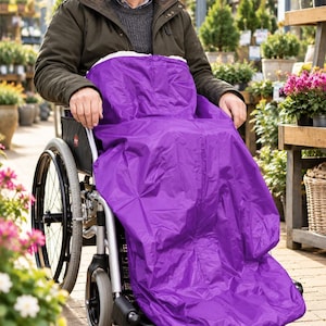 May include: A bright purple wheelchair blanket cover featuring a smooth, water-resistant outer shell and a soft, white fleece-lined interior. The cover is designed to drape over the legs and lower body, providing full coverage while seated.
