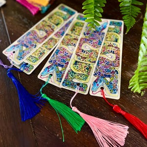 May include: Five colourful bookmarks with a snake design. Each bookmark has a different coloured tassel.