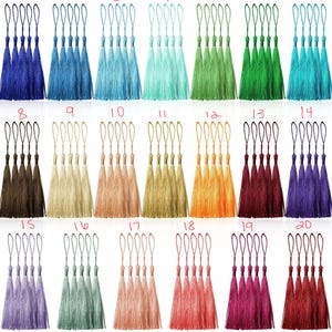 May include: Twenty different colours of tassel trim, each colour shown in a set of five tassels. The tassels are made of a soft, silky material and have a loop at the top for easy attachment.