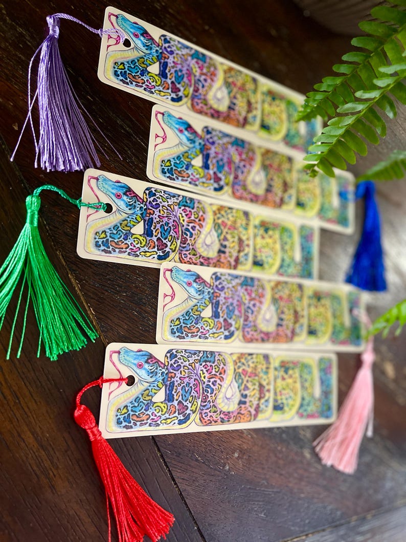 May include: Set of five colourful bookmarks featuring a detailed illustration of a snake with a patterned skin. Each bookmark has a tassel attached.