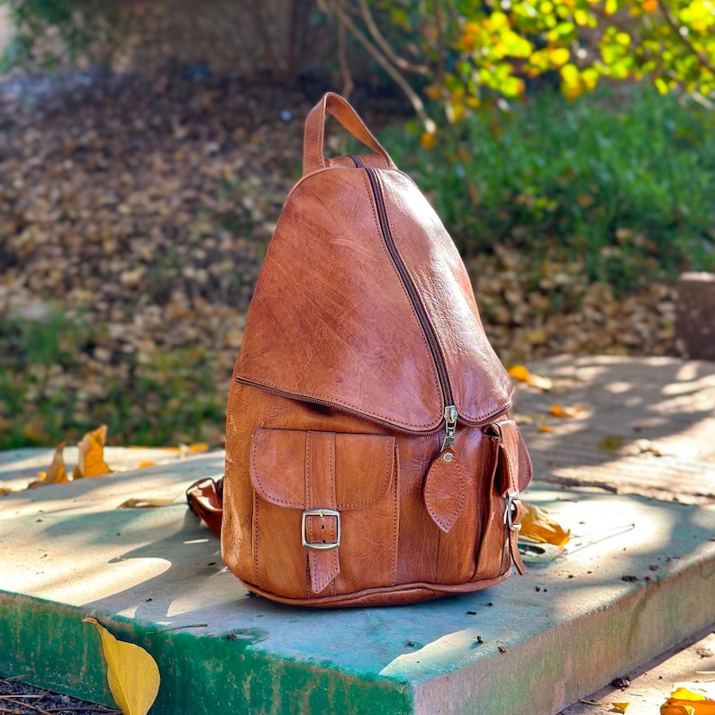 the side of Brown handmade leather backpack, womens backpack, leather Rucksack, 2 pockets on the front, Zipped pockets, adjustable zipped pockets