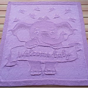 Op de afbeelding: Een lavendelkleurige gebreide babydeken met een geborduurde olifant en de tekst "Welcome Baby".