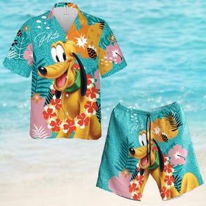 Może przedstawiać: Tropikalny zestaw koszuli i spodenek z Plutem, postacią Disneya, noszącą kwiatowy naszyjnik. Koszula i spodenki są turkusowe z różowymi, żółtymi i zielonymi wzorami kwiatowymi.