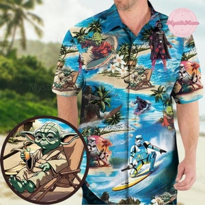 Op de afbeelding: Een blauw en wit Hawaiiaans overhemd met een tropisch strandtafereel met Star Wars-personages zoals Yoda, Darth Vader en Stormtroopers. De personages zijn te zien terwijl ze surfen, ontspannen op het strand en genieten van het tropische paradijs.