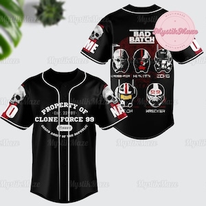 Puede incluir: Jersey de béisbol negro con un diseño blanco y rojo. La parte delantera del jersey tiene el texto "PROPERTY OF CLONE FORCE 99" y el texto "GRAND ARMY OF THE REPUBLIC". La parte posterior del jersey tiene el texto "THE BAD BATCH" y los nombres de los personajes "CROSSHAIR", "HUNTER", "ECHO", "TECH" y "WRECKER".