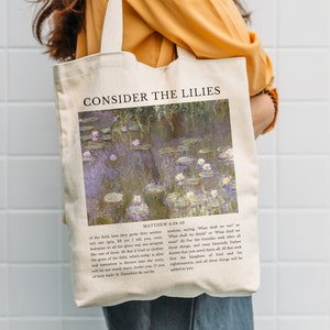 Könnte beinhalten: Eine weiße Canvas-Tragetasche mit einem Druck eines Seerosenbildes und dem Text "CONSIDER THE LILIES" sowie einem Bibelvers aus Matthäus 6:28-33.