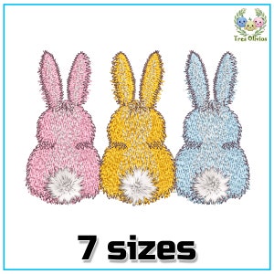 May include: Three embroidered bunny rabbits, one pink, one yellow, and one blue, with fluffy tails. The bunnies are sitting back to back. The text "7 sizes" is below the bunnies.